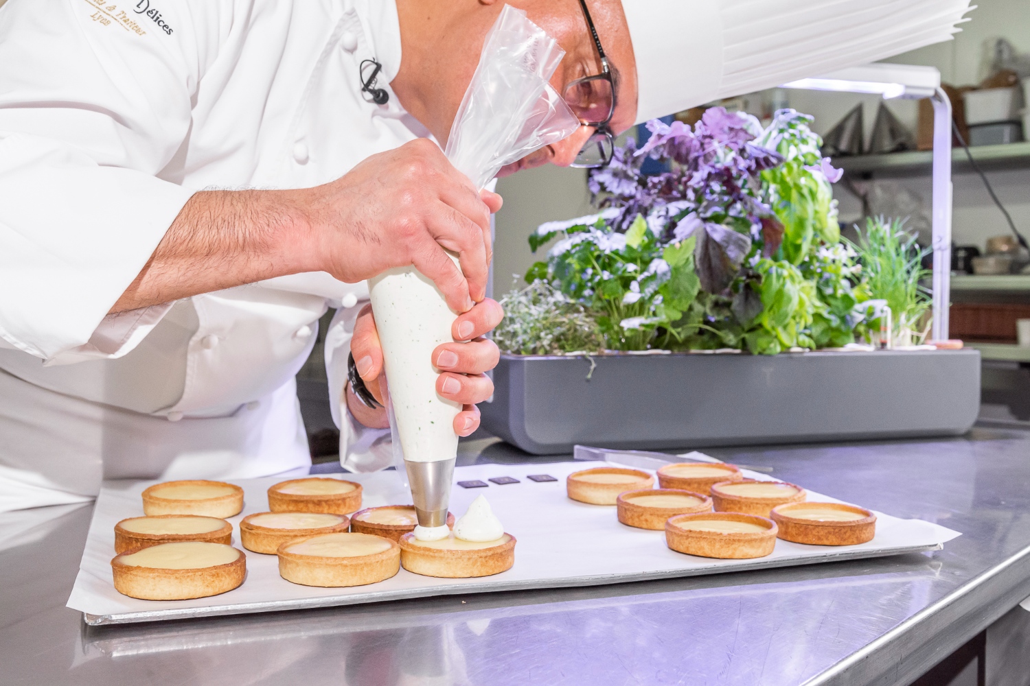 Chef Guzman finalisant ses tartes au citron avec les aromates Véritable